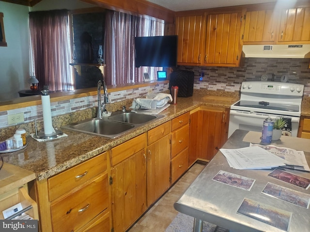 kitchen featuring a sink, brown cabinetry, under cabinet range hood, white range with electric stovetop, and tasteful backsplash
