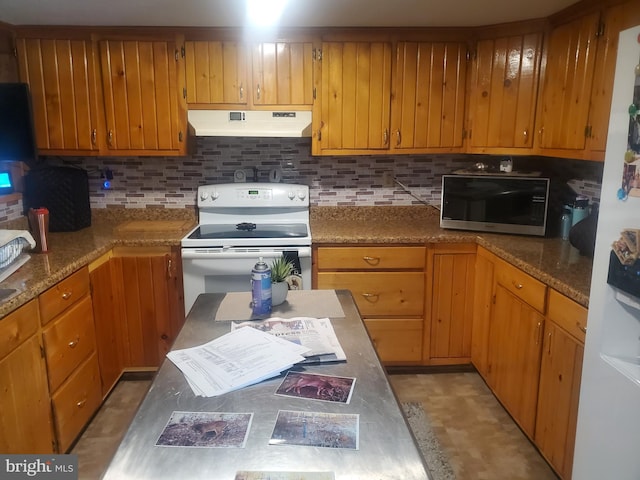 kitchen with white appliances, decorative backsplash, and under cabinet range hood
