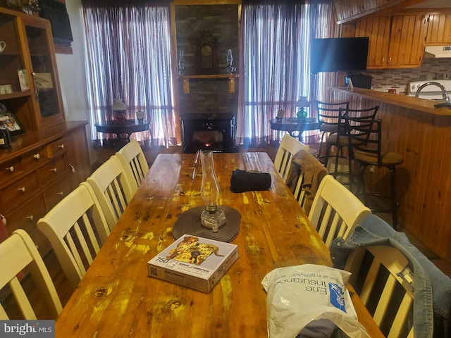 dining area featuring a large fireplace, a wealth of natural light, and wood finished floors