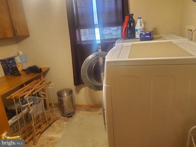 laundry area with washing machine and clothes dryer and cabinet space