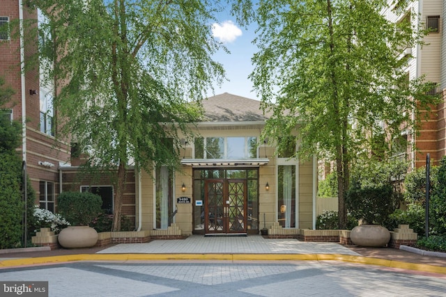entrance to property with roof with shingles and french doors