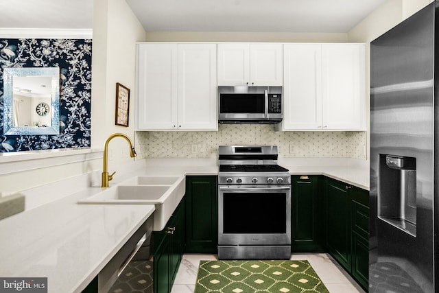 kitchen with a sink, light countertops, white cabinets, and appliances with stainless steel finishes