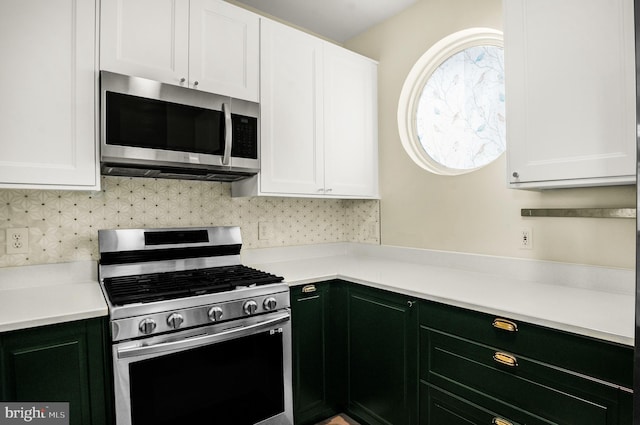 kitchen with stainless steel appliances, white cabinetry, light countertops, and decorative backsplash