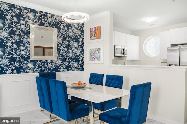 dining space featuring a wainscoted wall, visible vents, marble finish floor, and ornamental molding