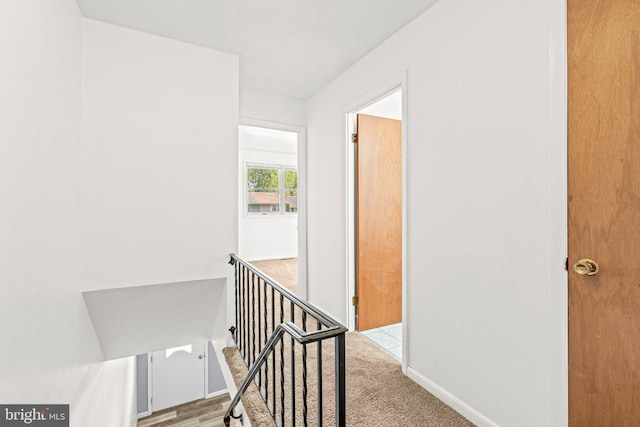 hallway featuring baseboards and an upstairs landing