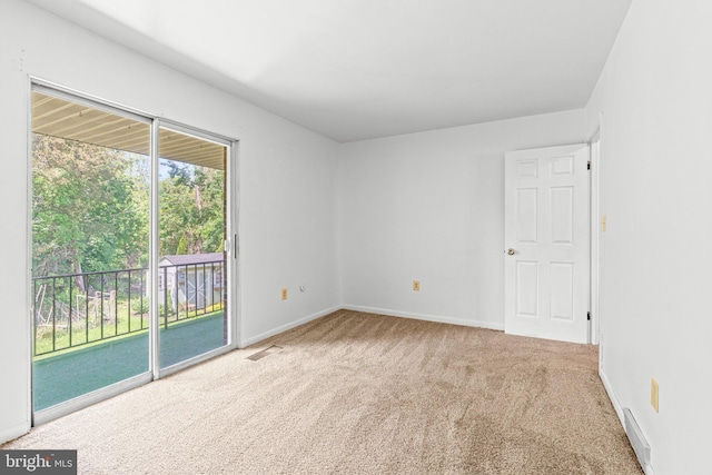 carpeted spare room featuring baseboards