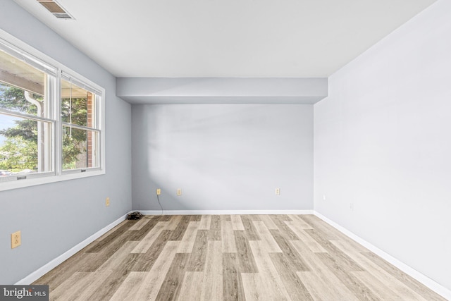 empty room featuring light wood-style flooring and baseboards