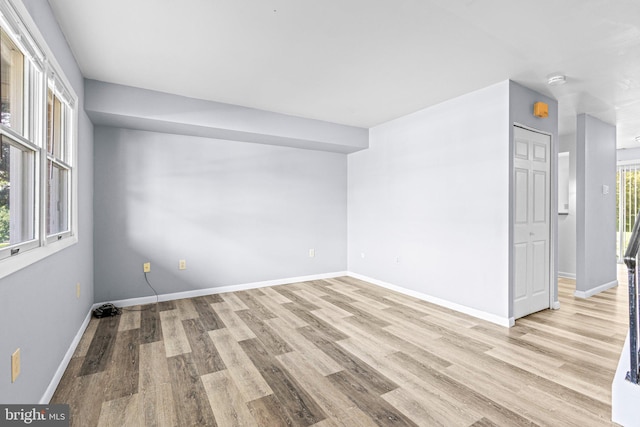 unfurnished room featuring light wood-type flooring and baseboards