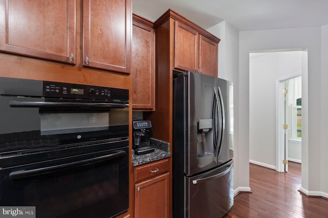 4111 Bayside Rd, Chesapeake Beach, MD 20732 - kitchen featuring stainless steel fridge, dark wood finished floors, baseboards, dark stone countertops, and brown cabinets