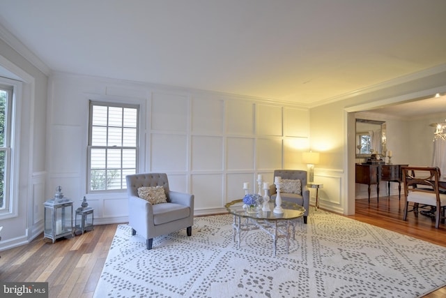 sitting room featuring a decorative wall, plenty of natural light, and wood finished floors