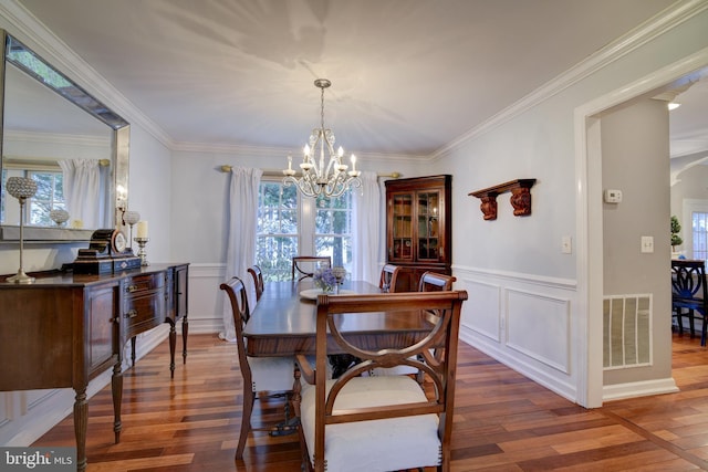 dining area featuring an inviting chandelier, visible vents, wood finished floors, and a healthy amount of sunlight