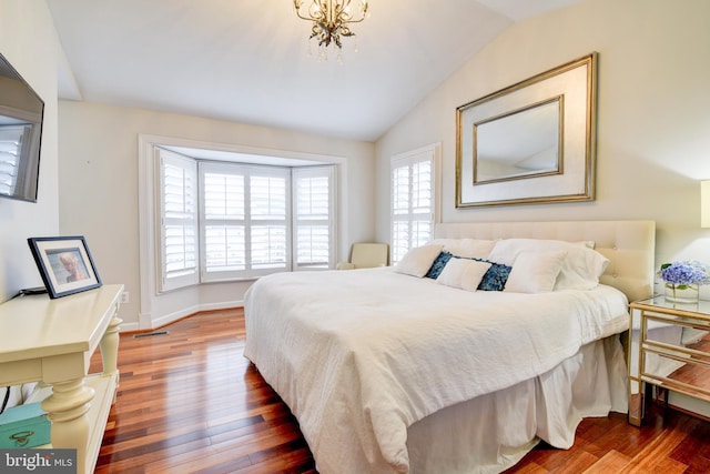 bedroom with wood finished floors, visible vents, vaulted ceiling, a notable chandelier, and baseboards