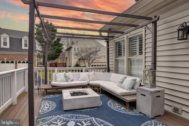 wooden terrace featuring an outdoor living space with a fire pit