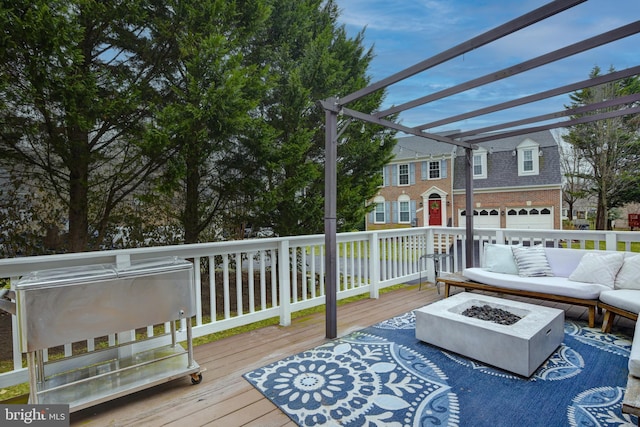 wooden terrace with an outdoor living space with a fire pit, a pergola, and an attached garage
