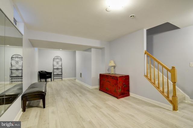 sitting room featuring baseboards, stairs, and wood finished floors
