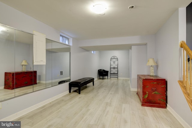 living area featuring light wood-style floors, visible vents, and baseboards