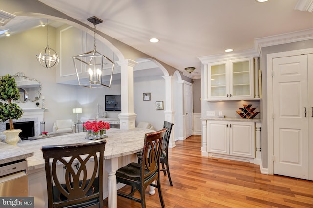 dining room featuring ornamental molding, ornate columns, recessed lighting, a chandelier, and light wood-style flooring