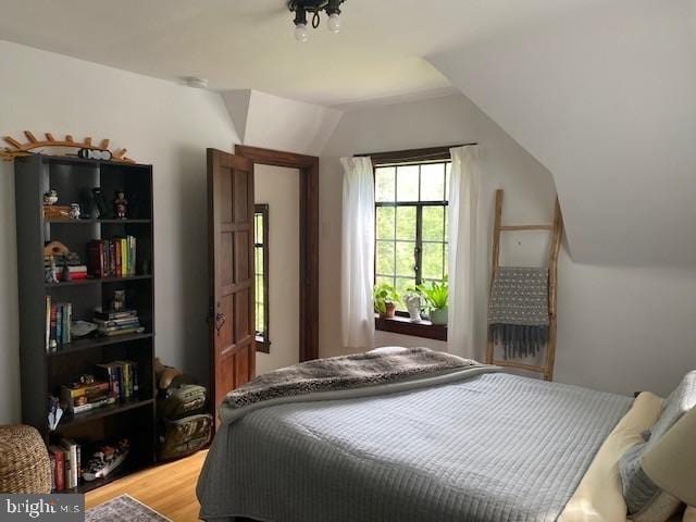 bedroom featuring vaulted ceiling and light wood-type flooring
