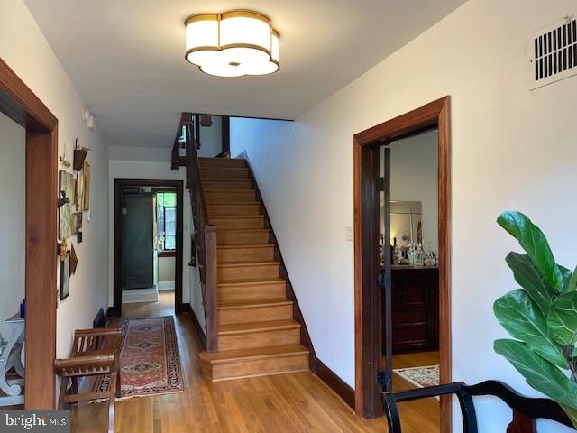 staircase featuring wood finished floors and baseboards