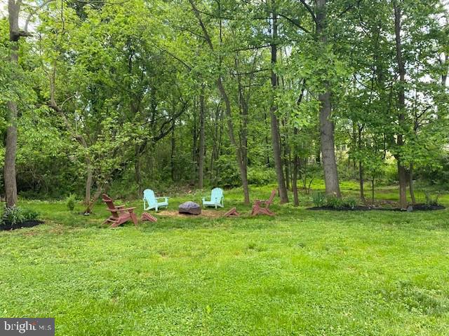 view of green lawn with a fire pit