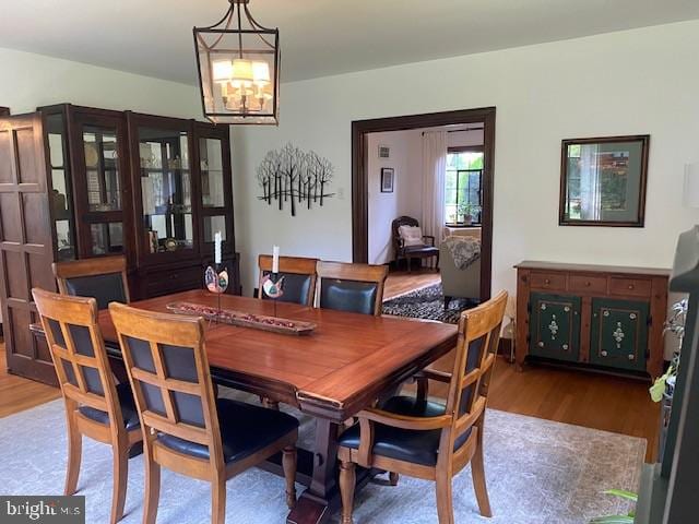 dining space featuring wood finished floors and a chandelier