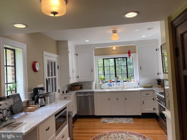 kitchen with stainless steel appliances, light wood-style floors, white cabinetry, light countertops, and recessed lighting
