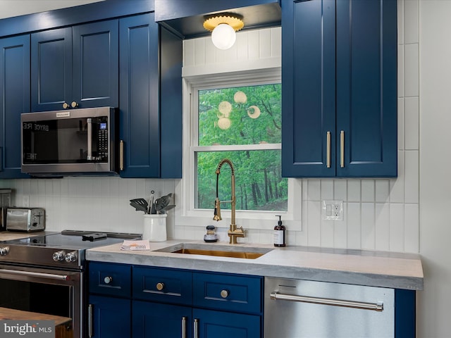 209 Hogan Dr, Basye, VA 22810 - kitchen featuring appliances with stainless steel finishes, blue cabinets, a sink, light countertops, and tasteful backsplash