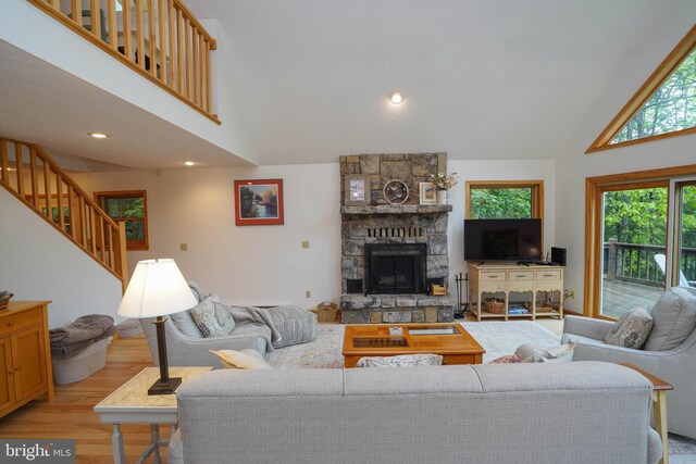 2119 Rock Lodge Rd, Mc Henry, MD 21541 - living room featuring high vaulted ceiling, light wood-type flooring, a stone fireplace, stairs, and recessed lighting