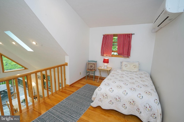 2119 Rock Lodge Rd, Mc Henry, MD 21541 - bedroom featuring a wall unit AC, a skylight, wood finished floors, and baseboards