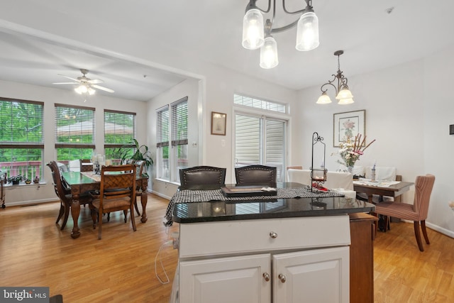 5533 Westcott Cir, Frederick, MD 21703 - kitchen with a chandelier, light wood finished floors, a ceiling fan, white cabinets, and pendant lighting