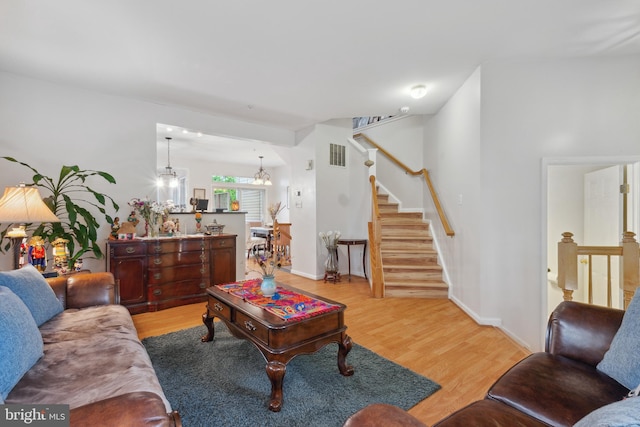 5533 Westcott Cir, Frederick, MD 21703 - living room with wood finished floors, stairway, a chandelier, and baseboards