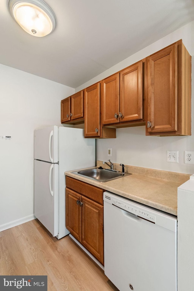4931 Americana Dr Unit 4931B, Annandale, VA 22003 - kitchen with dishwasher, light wood-style floors, a sink, brown cabinets, and light countertops