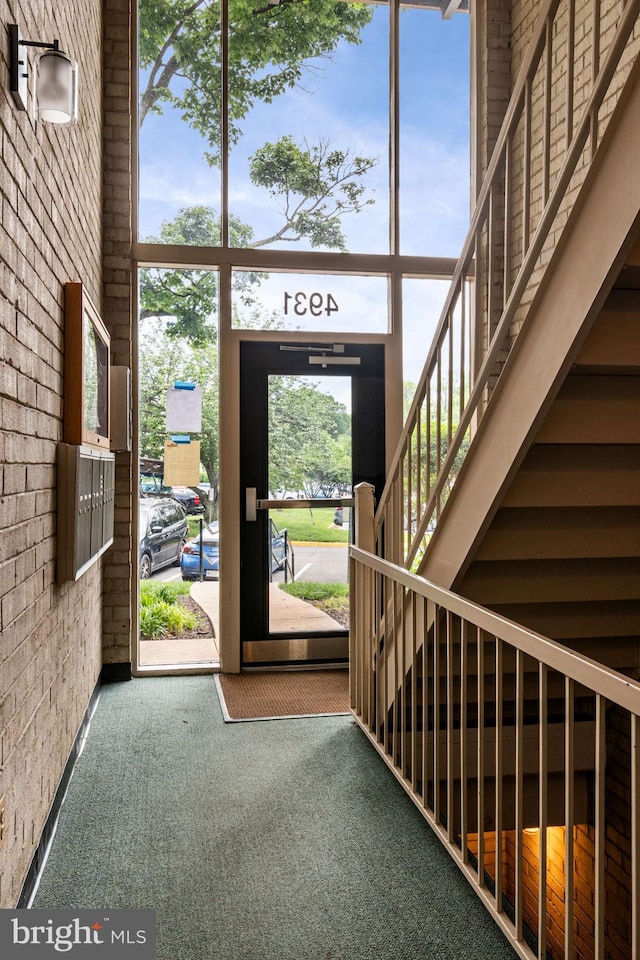 4931 Americana Dr Unit 4931B, Annandale, VA 22003 - entrance foyer featuring carpet floors, brick wall, healthy amount of natural light, and a towering ceiling