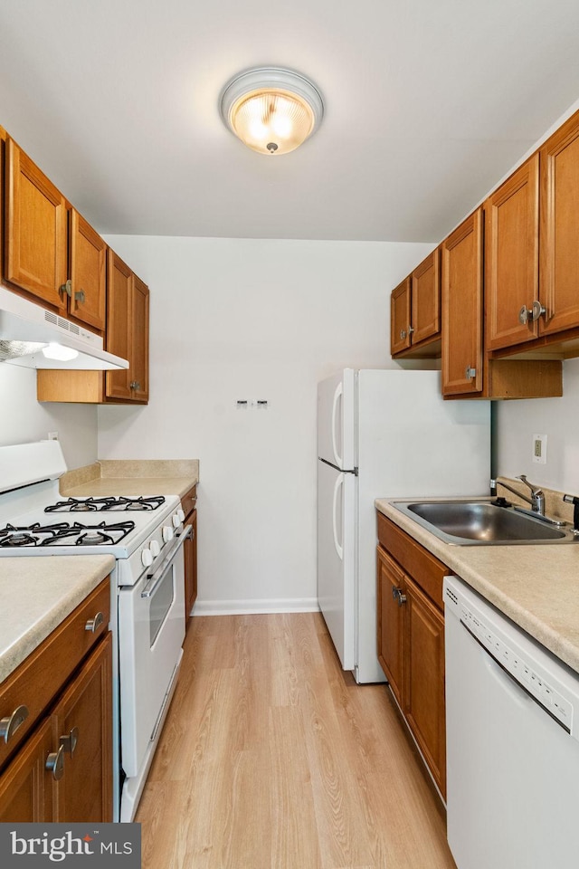 4931 Americana Dr Unit 4931B, Annandale, VA 22003 - kitchen featuring white appliances, under cabinet range hood, a sink, light wood finished floors, and brown cabinets