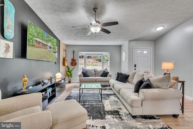 486 Round Up Rd, Lusby, MD 20657 - living area featuring ceiling fan, wood finished floors, baseboards, and a textured ceiling