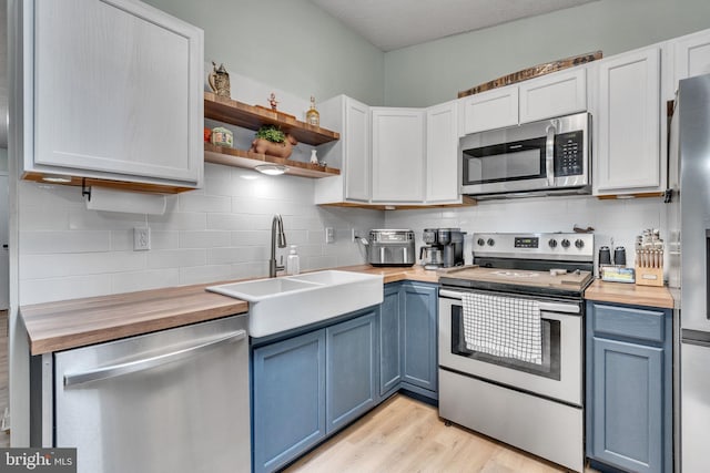486 Round Up Rd, Lusby, MD 20657 - kitchen with butcher block counters, appliances with stainless steel finishes, and blue cabinetry