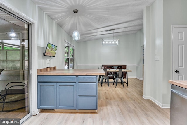 486 Round Up Rd, Lusby, MD 20657 - kitchen with light wood finished floors, blue cabinets, butcher block countertops, hanging light fixtures, and baseboards