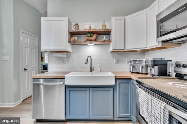 486 Round Up Rd, Lusby, MD 20657 - kitchen featuring appliances with stainless steel finishes, a sink, backsplash, and blue cabinetry