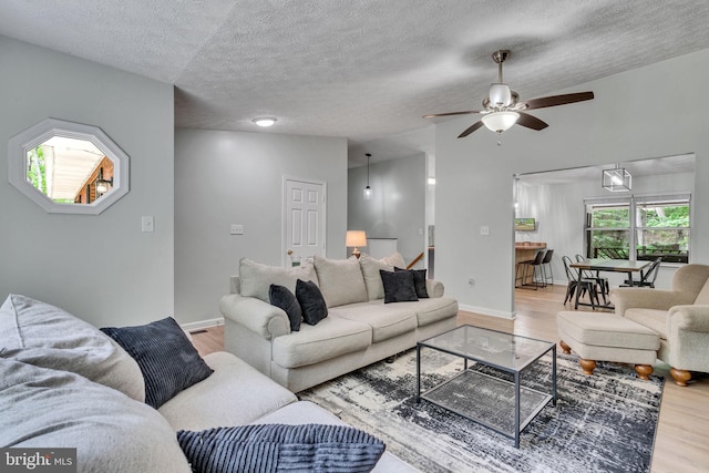 486 Round Up Rd, Lusby, MD 20657 - living room featuring wood finished floors, a ceiling fan, a textured ceiling, and baseboards