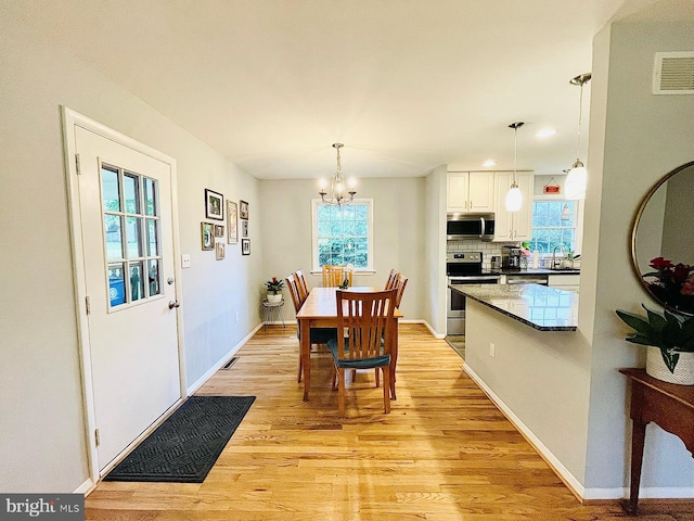 12112 Bayswater Rd, Gaithersburg, MD 20878 - dining room featuring light wood-type flooring, a chandelier, and baseboards