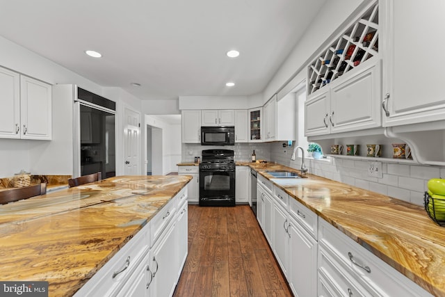 kitchen with black appliances, a sink, dark wood-type flooring, white cabinetry, and recessed lighting