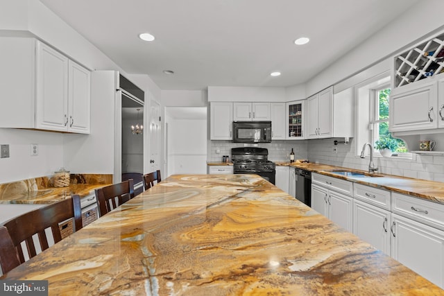 kitchen featuring black appliances, a sink, white cabinets, backsplash, and recessed lighting