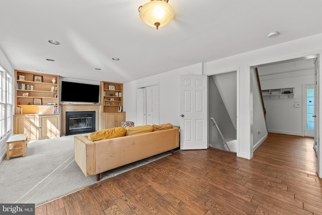 living area with a glass covered fireplace, wood finished floors, baseboards, and recessed lighting