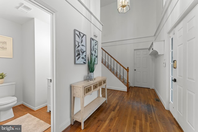 entryway featuring stairway, wood finished floors, and baseboards