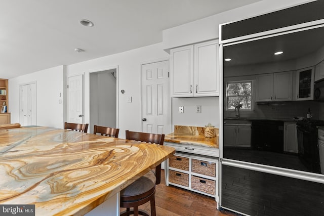 kitchen with black appliances, dark wood-type flooring, glass insert cabinets, backsplash, and white cabinets
