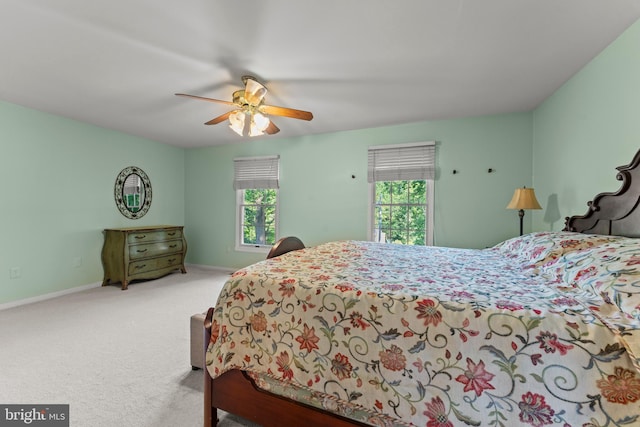 carpeted bedroom featuring baseboards and a ceiling fan