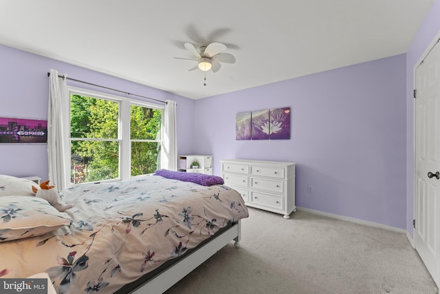 bedroom with light carpet, baseboards, and a ceiling fan