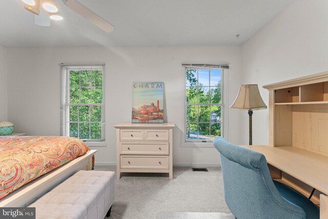 bedroom with multiple windows, light carpet, baseboards, and a ceiling fan