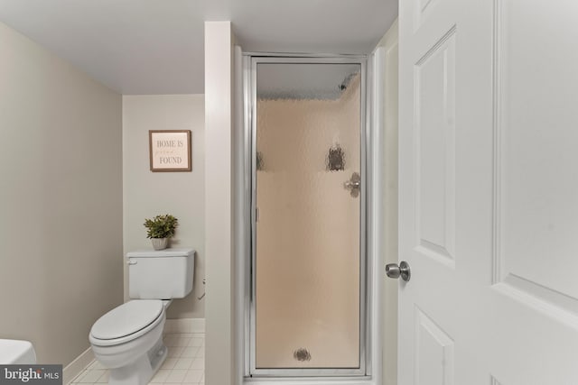 full bathroom featuring a shower stall, baseboards, toilet, and tile patterned flooring