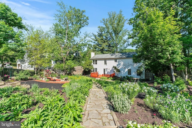 view of yard featuring a vegetable garden, fence, and a wooden deck